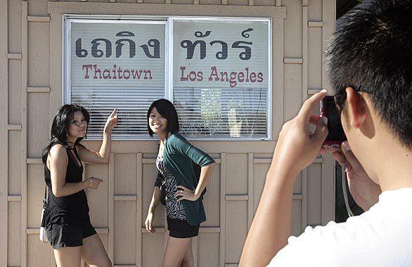 Steve Vannavong photographs friends Chanhsamone Sysouphanh, left, and Abby Panyanouvong, during a visit to Thai Town on Hollywood Boulevard in Los Angeles.
