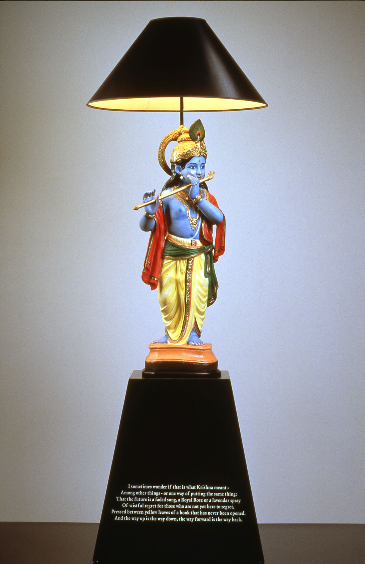 John Boskovich, “Hare Krishn Lamp 1,” 1997. Found papier-mache statuette, metal and electrical lamp fittings, paper shade, black formica base with T.S. Eliot text, 75 inches by 23 and one-eighth inches by 22 and seven-eighths inches