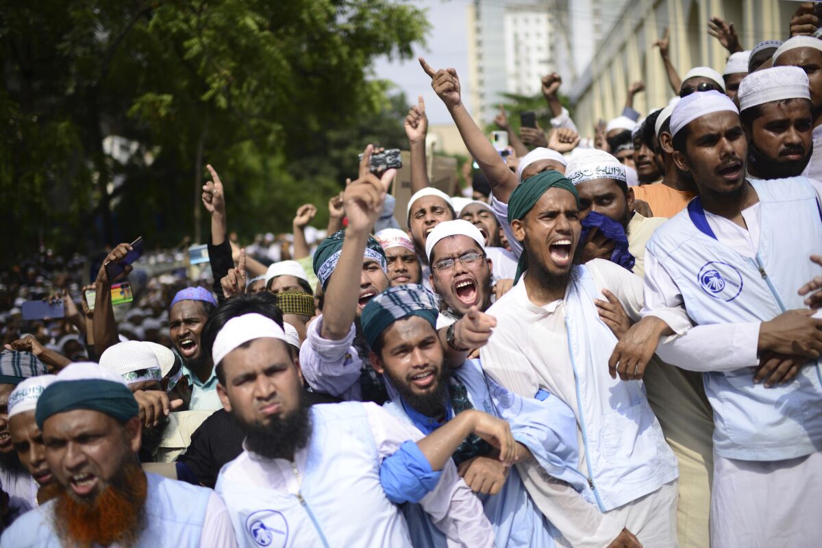 Muslims shout slogans against Nupur Sharma, a spokesperson of India's governing Hindu nationalist party as they react to the derogatory references to Islam and the Prophet Muhammad made by her, during a protest outside a mosque in Dhaka, Bangladesh, Friday, June 10, 2022. Thousands of people marched in Bangladesh's capital on Friday to urge Muslim-majority nations to cut off diplomatic ties with India and boycott its products unless it punishes two governing party officials for comments deemed derogatory to Islam's Prophet Muhammad. (AP Photo/Mahmud Hossain Opu)