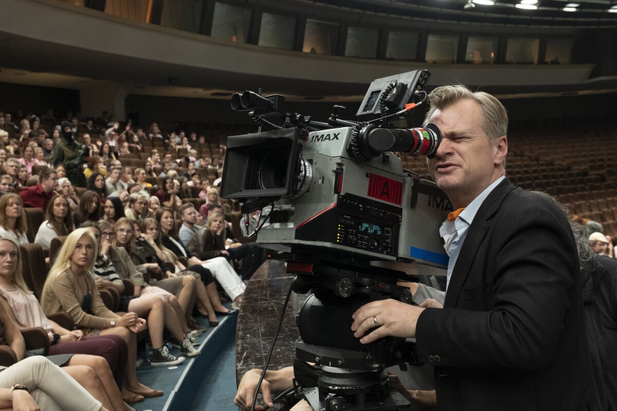 This image released by Warner Bros. Entertainment shows director Christopher Nolan during the filming of "Tenet." On Tuesday, audiences will finally be able to watch, re-watch and dissect the palindromic spy thriller starring John David Washington, Robert Pattinson and Elizabeth Debicki from the comfort of their home. The film will be available on 4K, DVD, Blu-ray and digital with behind the scenes extras that give a peek into the mind-bogglingly complex process of shooting a large-scale action film. (Melinda Sue Gordon/Warner Bros. Entertainment via AP)