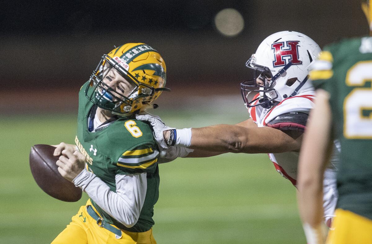 Edison's Braeden Boyles is pushed out of bounds by Heritage's Issac Hernandez in the first round of the CIF Southern Section Division 3 playoffs on Friday at Huntington Beach High.
