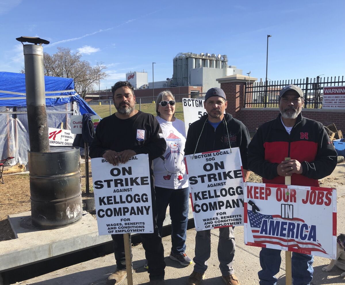 Omaha Striking Kellogg's workers Michael Rodarte, Sue Griffin, Michael Elliott and Mark Gonzalez stand outside the Omaha, Neb., cereal plant Thursday, Dec. 2, 2021. The company and the union announced Thursday that they have reached a tentative contract agreement. (AP Photo/ Josh Funk)