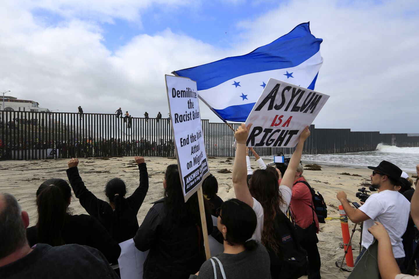 Groups on both sides of the border rally Sunday before immigrants from the caravan across Mexico were to seek asylum at the border with the U.S.