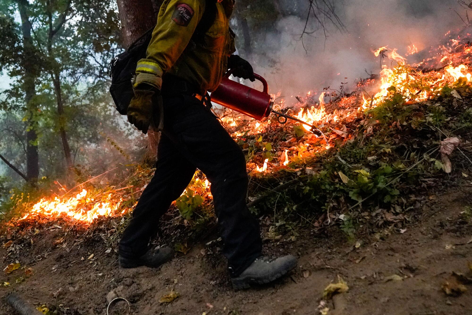 Cal Fire firefighter Mike Quatela sets a back fire