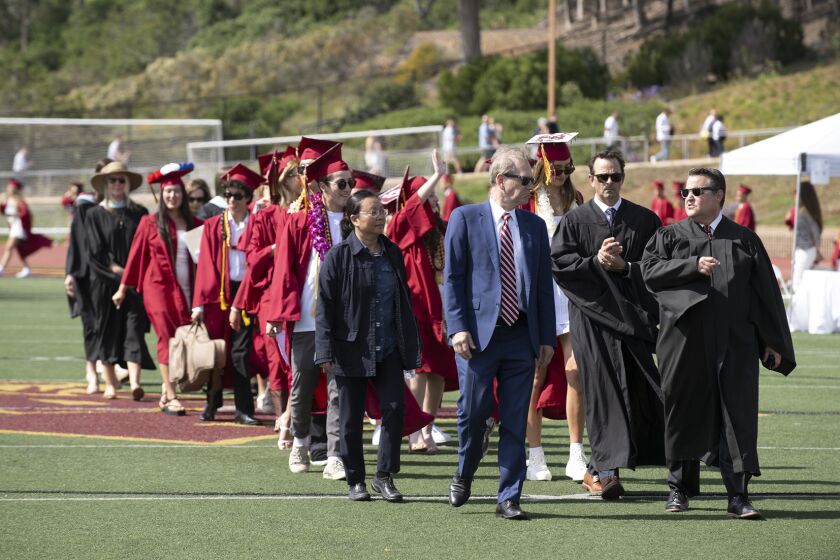 SDUHSD trustees Phan Anderson and Michael Allman, Associate Superintendent Bryan Marcus, and TPHS Principal Rob Coppo lead the graduates onto the field