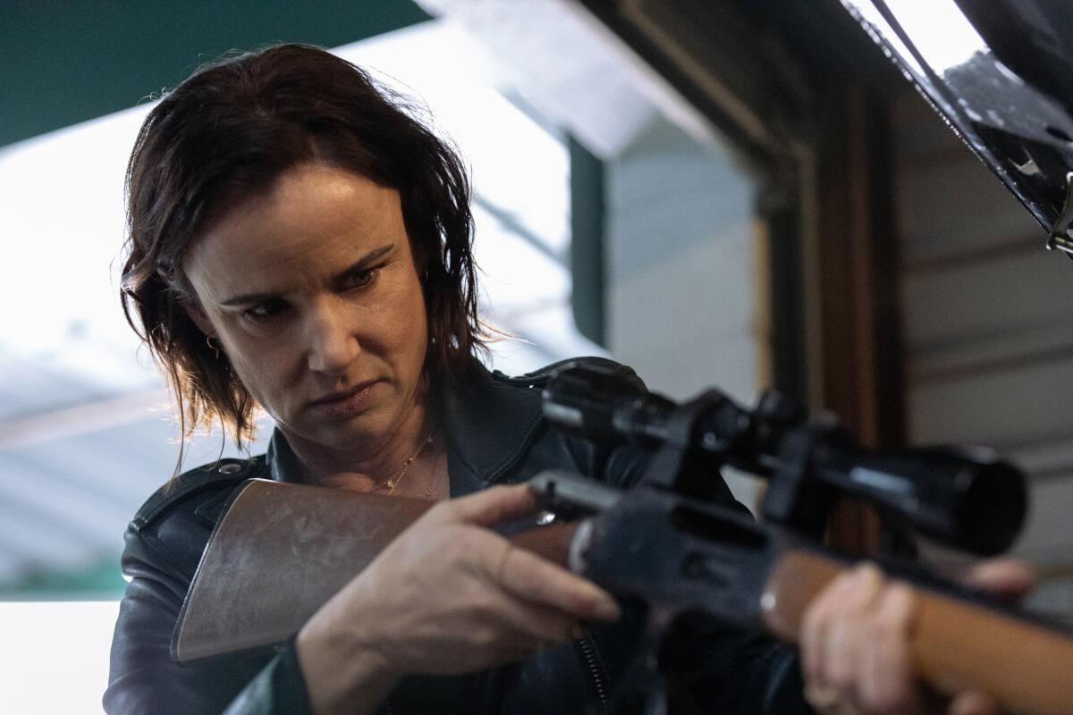  A woman (Juliette Lewis) holds a rifle with a sniper scope on "Yellowjackets."