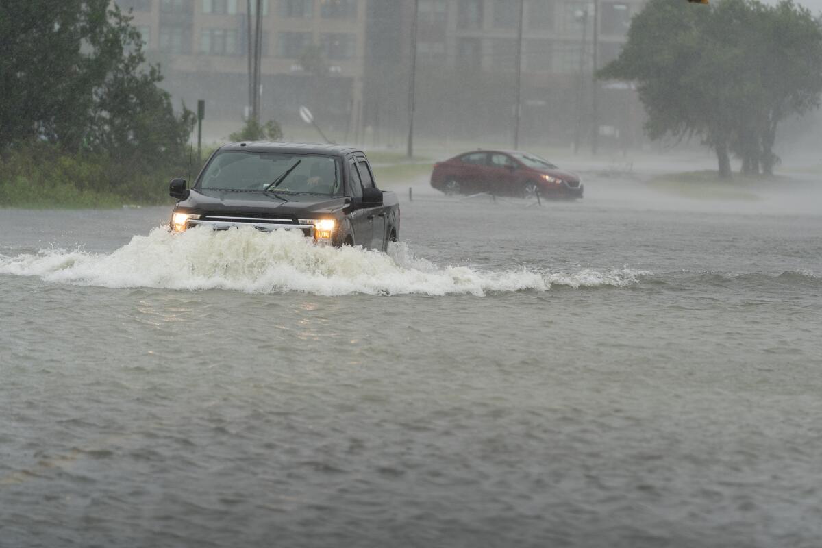 Un automovilista avanza a través de una calle inundada 