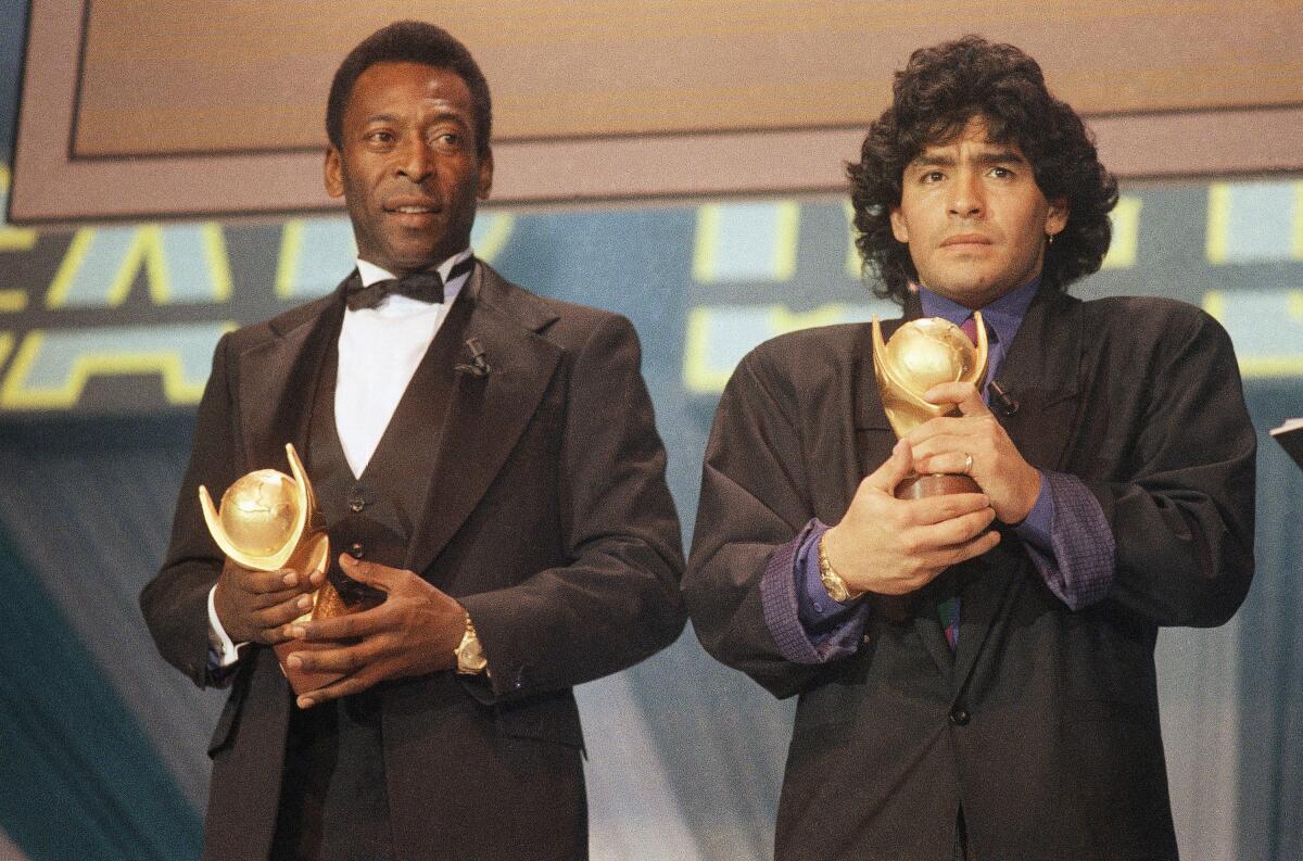 Pelé, left, and Diego Maradona hold trophies during an award ceremony in 1987.