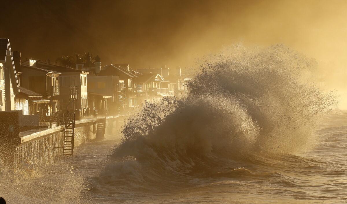 As the suns rises ove the Solimar burn area west of Ventura,heavy surf slams the homes at Mondo's Beach between the Solimar and Faria Beach communities Thursday morning.