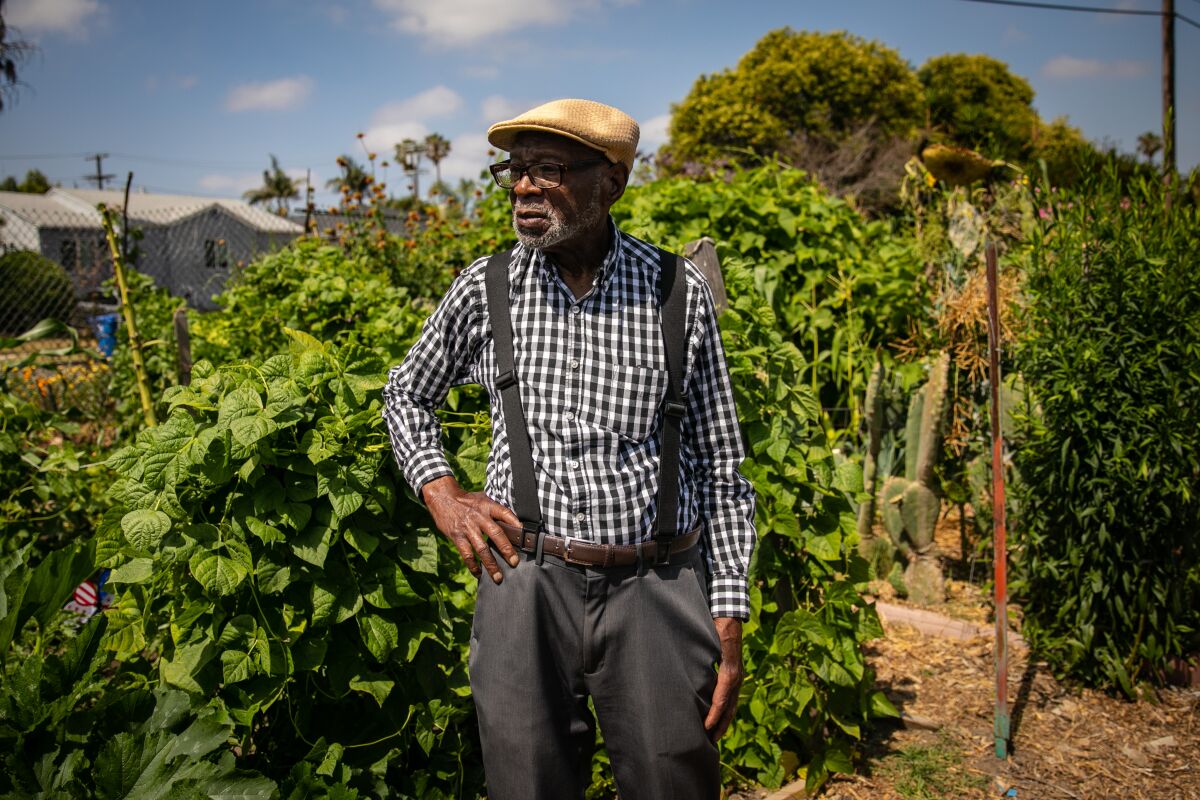 An elderly man wearing a hat stands in the Good Earth Community Garden in South L.A.