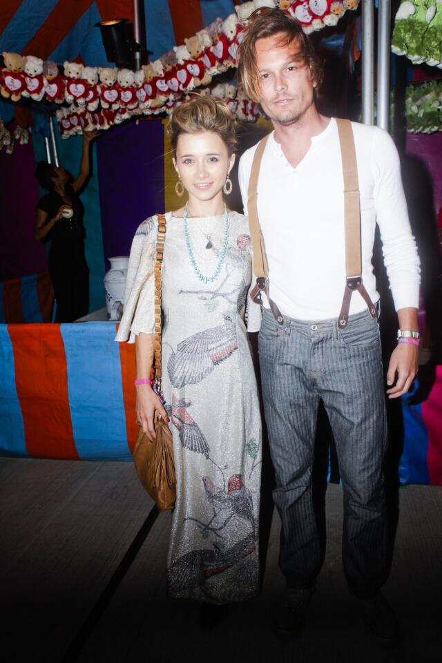 Olesya Rulin sports a vintage look and a Tory Burch bag and Andrew Gray McDonnell wears Stronghold at the Armani Exchange Neon Carnival, one of many parties held during the first weekend of the Coachella Valley Music and Arts Festival.