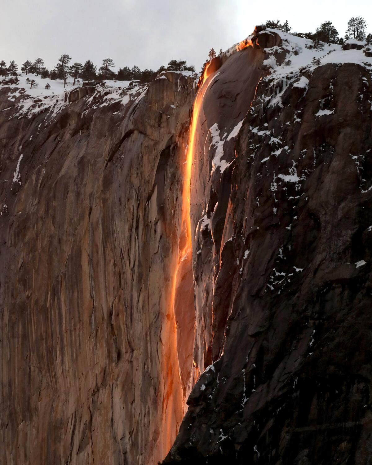 What looks like a stream of red lava is seen on the face of a cliff.