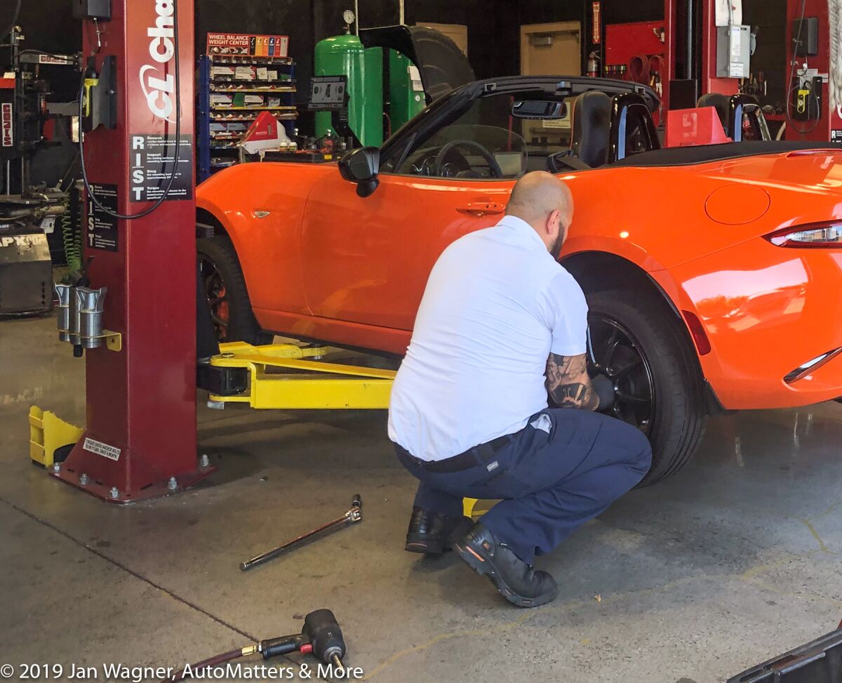 Installing the repaired tire on the car.