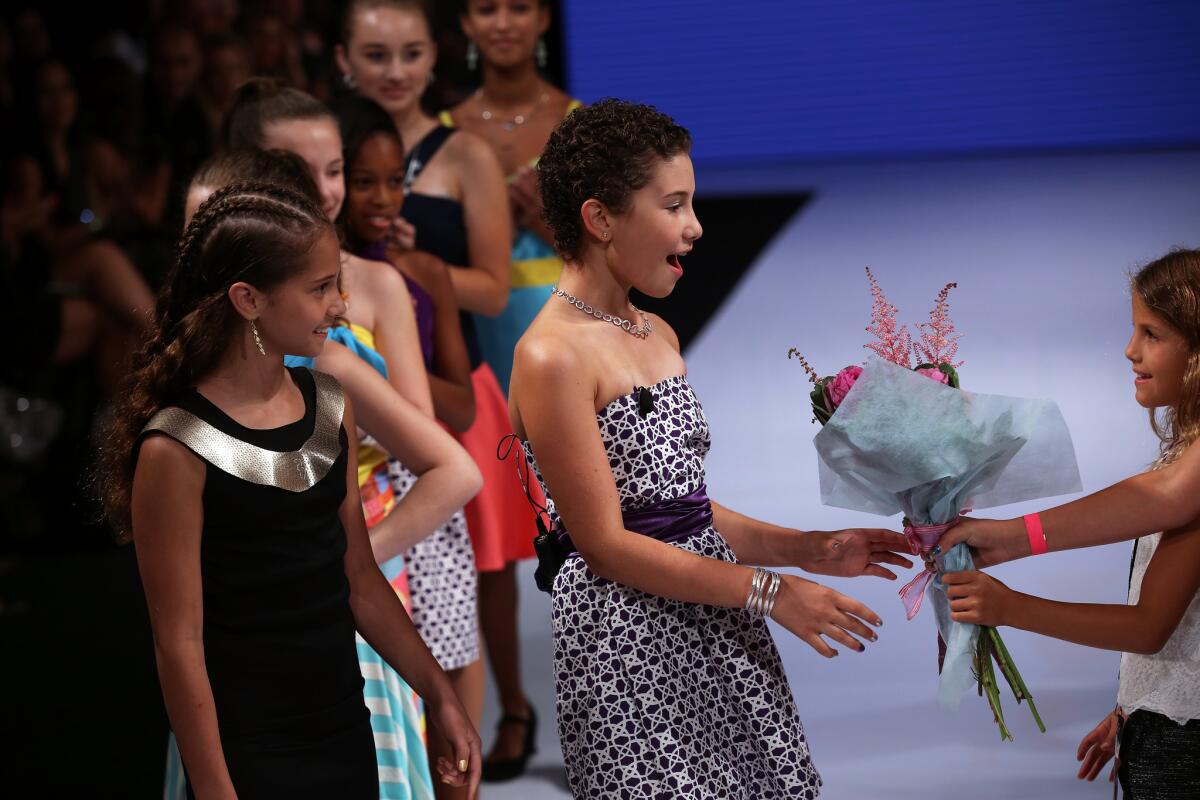 Noa Sorrell, 11, second from right, is presented with flowers after her fashion line made its debut Oct. 7 during Art Hearts Fashion at the Tagylan Complex in Hollywood, part of Los Angeles fashion week.