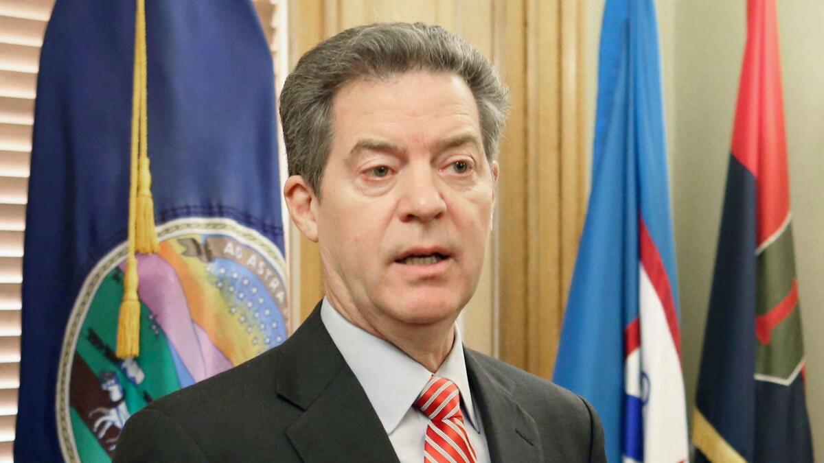 Kansas Gov. Sam Brownback vetoed a bill that would have expanded the state's Medicaid program, saying Kansas could not absorb the costs even with federal funding for the effort.