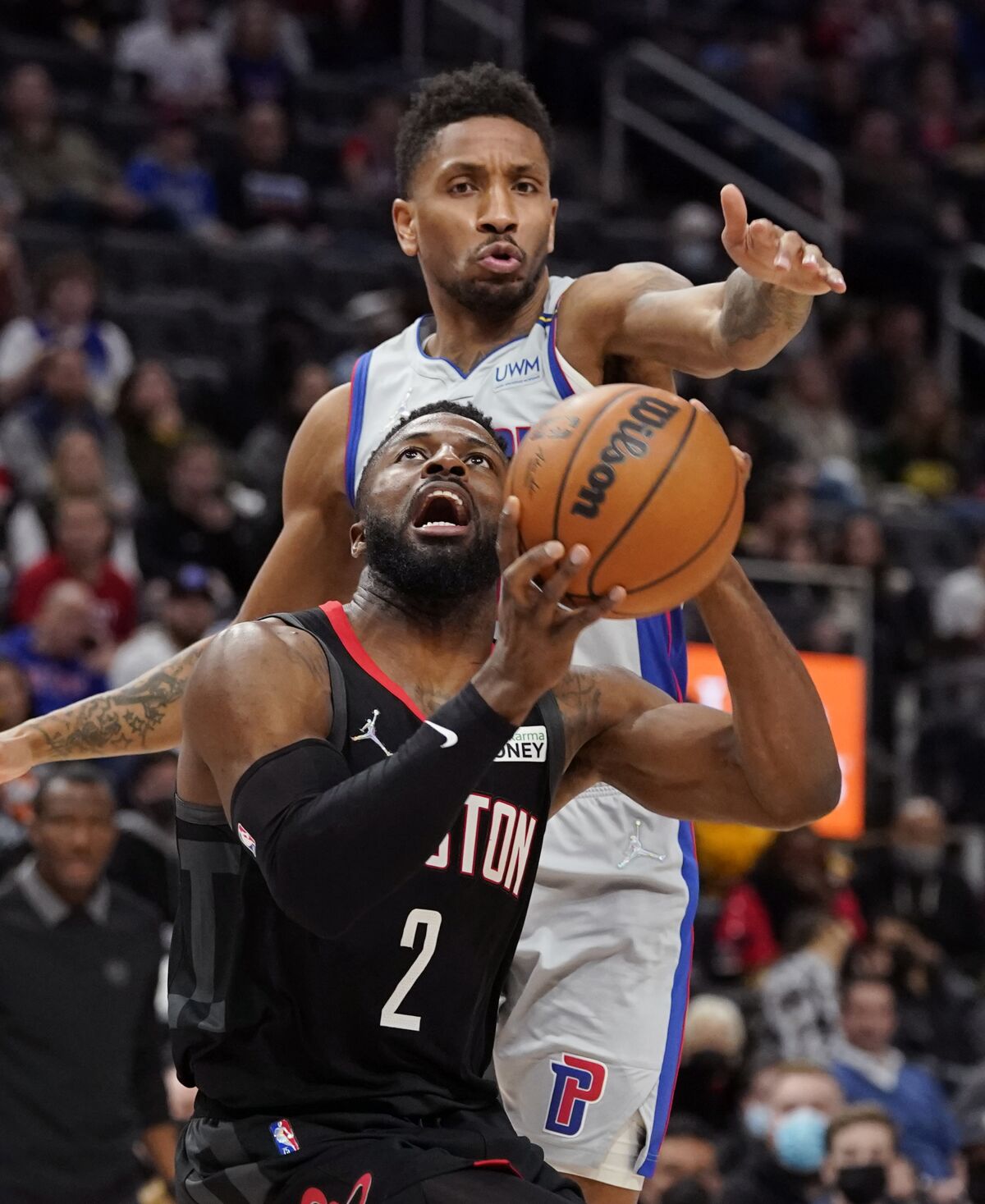 Detroit Pistons guard Rodney McGruder attempts to block Houston Rockets forward David Nwaba (2) during the second half of an NBA basketball game, Saturday, Dec. 18, 2021, in Detroit. (AP Photo/Carlos Osorio)