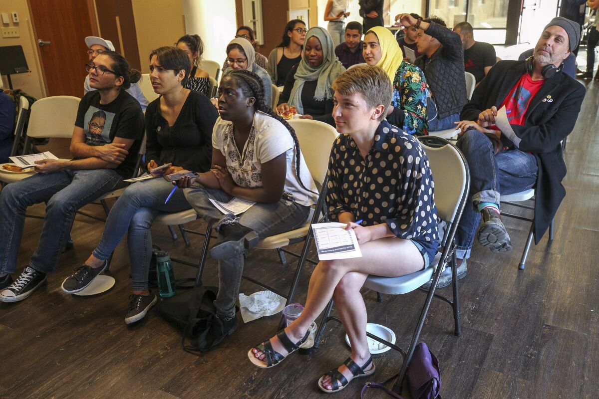 A group of mostly young adults watch the Democratic presidential debate during a watch party, put on by Youth Will, at the Jacobs Center For Neighborhood Innovation on Wednesday, June 26, 2019 in San Diego, California.