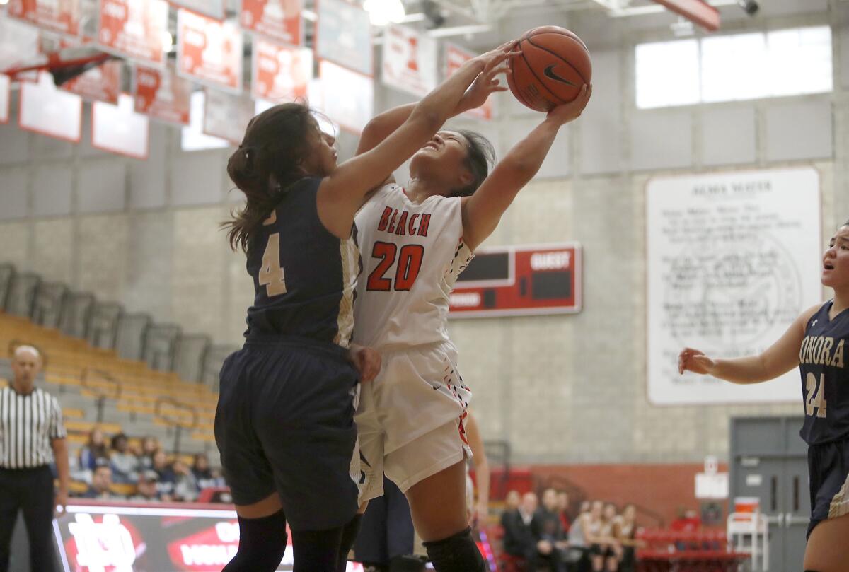 Huntington Beach's Marisa Tanga (20) is fouled by Sonora's Luz Lizardo during a game in the Matt Denning Nike Hoops Classic at Mater Dei High on Jan. 5.