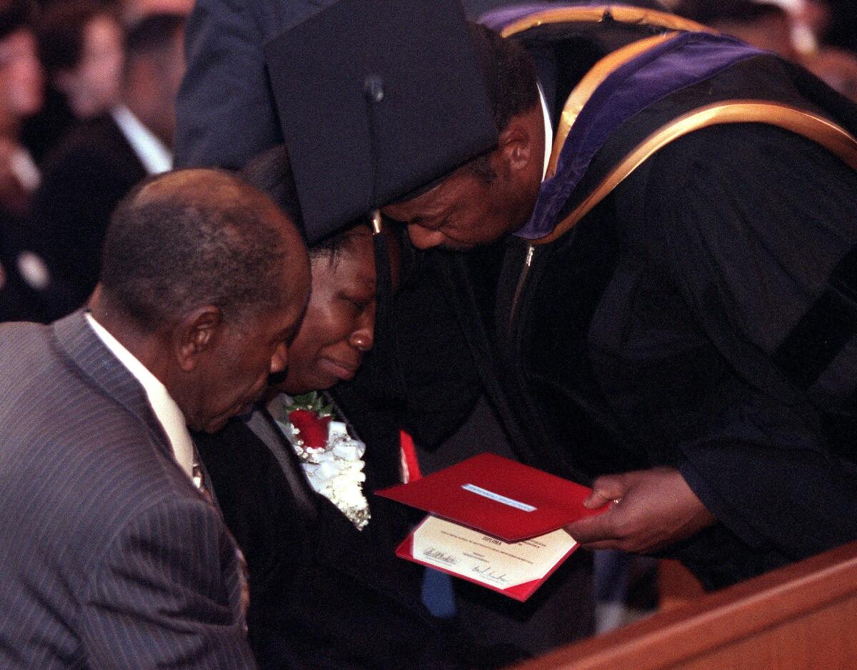 Loretta Thomas Davis, mother of slain student Corie Williams, and Corie's stepfather Willie Davis receive the diploma her daughter would have received. Corie was an innocent victim of gang violence on a city bus.