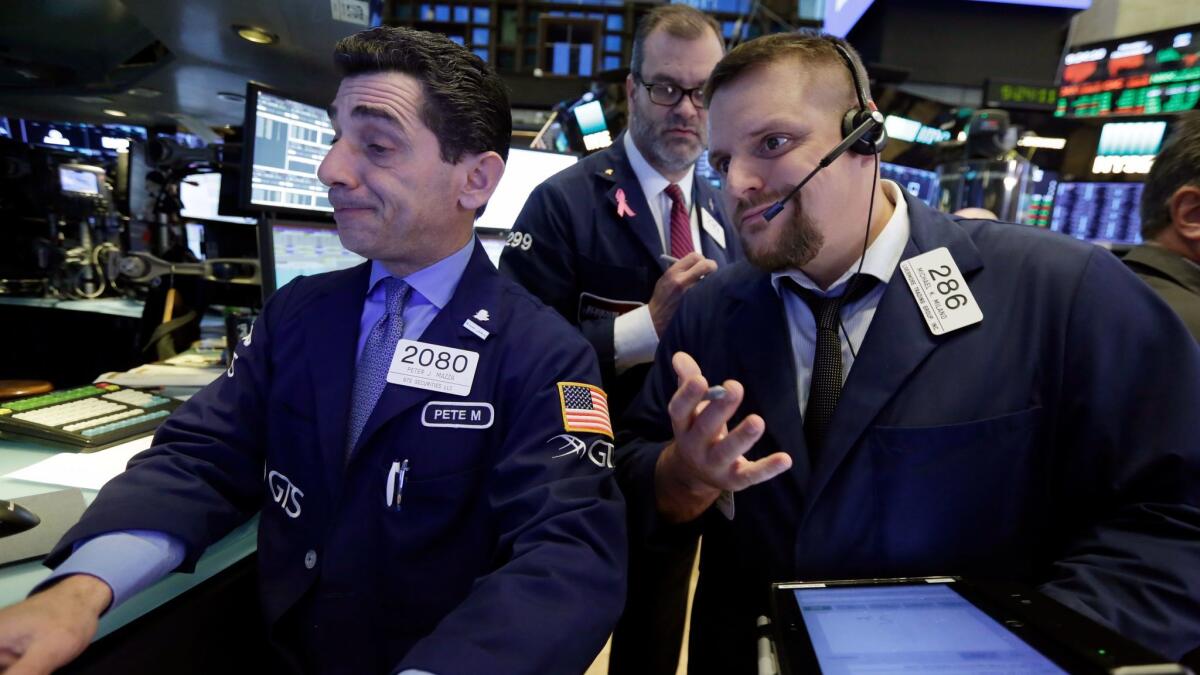 Chip makers surged after Broadcom offered to buy competitor Qualcomm for $103 billion. Above, workers on the floor of the New York Stock Exchange.