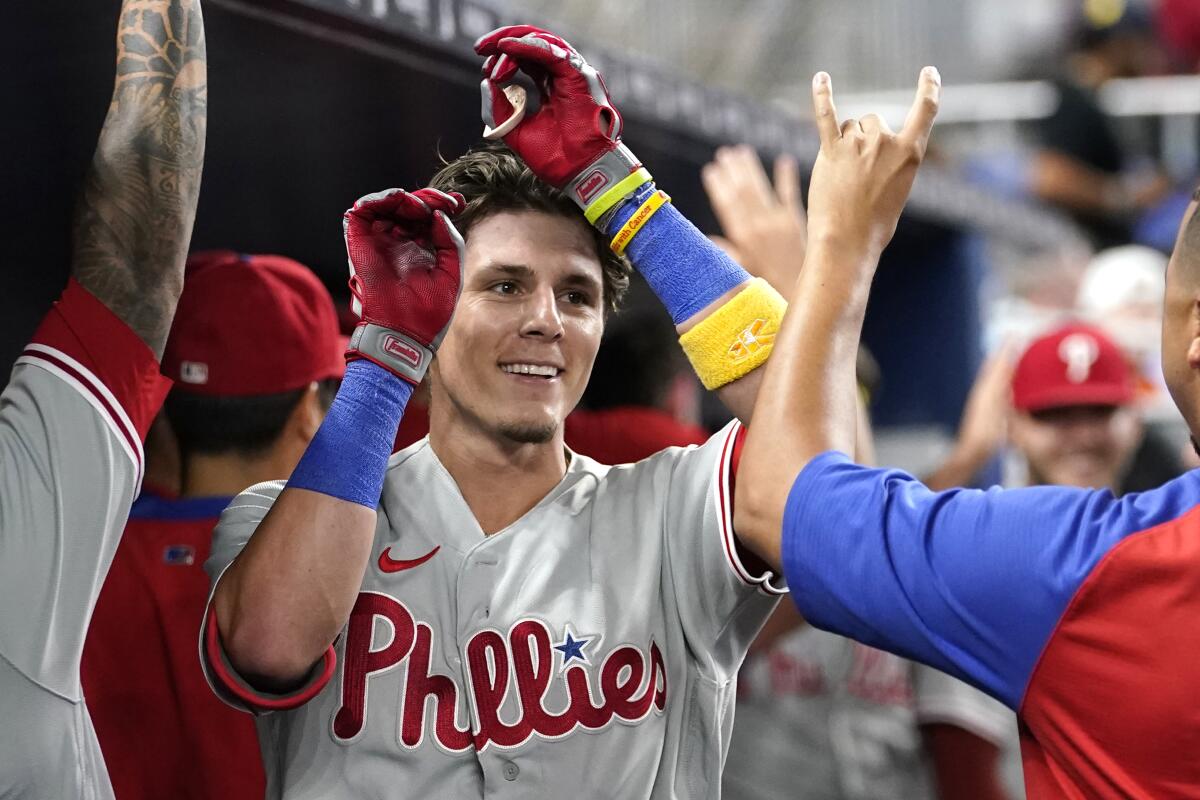 Philadelphia Phillies' Nick Maton is congratulated in the dugout after hitting a two-run home run during the seventh inning of a baseball game against the Miami Marlins, Tuesday, Sept. 13, 2022, in Miami. The Phillies won 2-1. (AP Photo/Lynne Sladky)