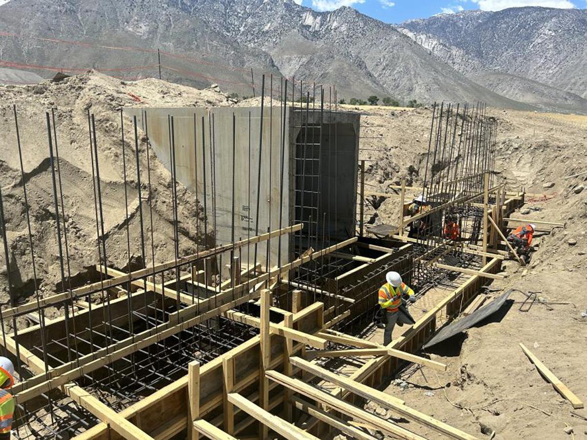 Work crews assemble concrete forms at a building site.