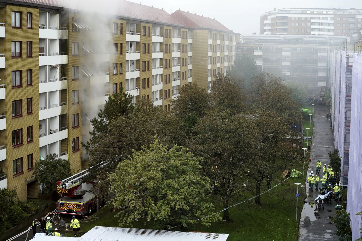 FILE - In this Tuesday Sept. 28, 2021 file photo, smoke billows from an apartment building after an explosion in Annedal, central Gothenburg, Sweden. Swedish police say a woman who was seriously injured in last month's huge apartment building explosion and fire in Sweden has died. At least 140 apartments were damaged and four people were seriously hurt, including the woman who has now died. Earlier this month, the suspect in the explosion was found dead in the Goteborg harbor, only a few kilometers (miles) from the building that was blown up on Sept. 28. Police said Friday, Oct. 15, 2021 that a preliminary statement by the medical examiner concludes that the cause of the suspect's death has not yet been determined, but they do not suspect foul play. (Bjorn Larsson Rosvall/TT via AP, File)