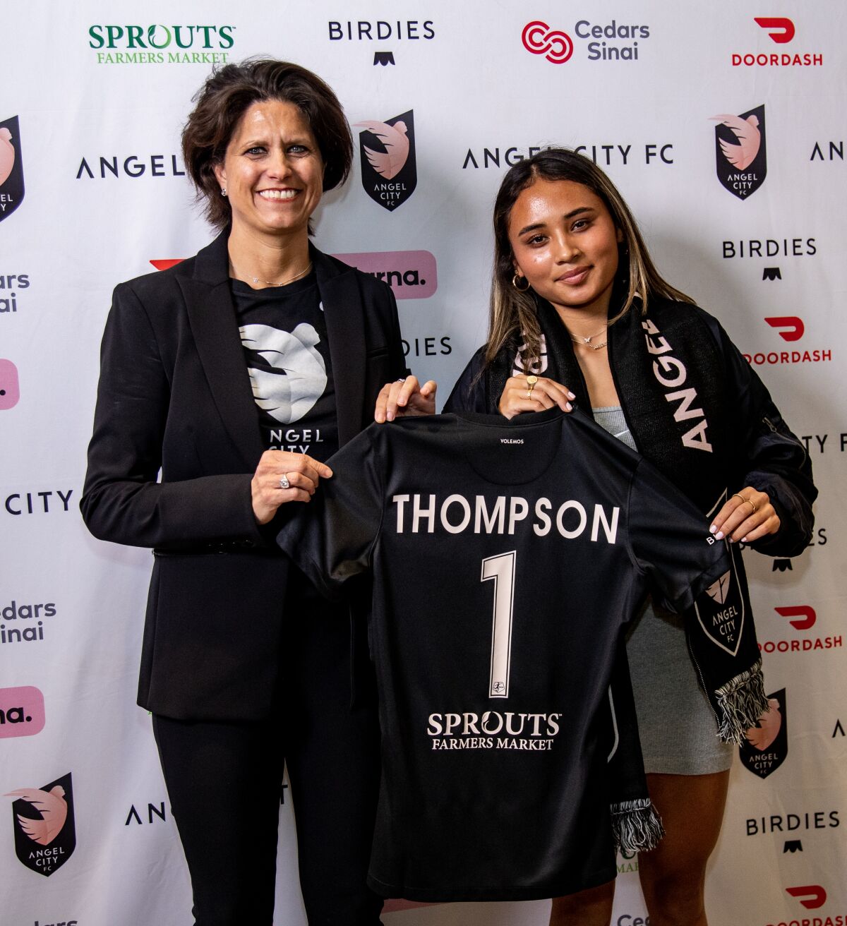 Alyssa Thompson (à gauche) porte son maillot Angel City avec la présidente d'Angel City, Julie Ahman.