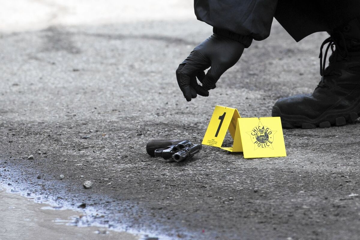 An evidence marker is placed next to a gun at a shooting in East Garfield Park on March 16, 2016.