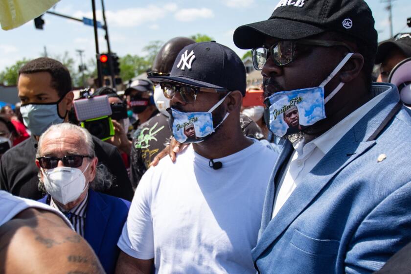 MINNEAPOLIS , MINNESOTA - JUNE 01: Terrence Floyd (center) pays their respects at the makeshift memorial outside Cup Foods where his brother George Floyd was murdered by a Minneapolis police officer on Monday, June 1, 2020 in Minneapolis , Minnesota. Terrence is joined by his lawyer Sanford Rubenstein (left) and Rev. Kevin McCall (right) (Jason Armond / Los Angeles Times)