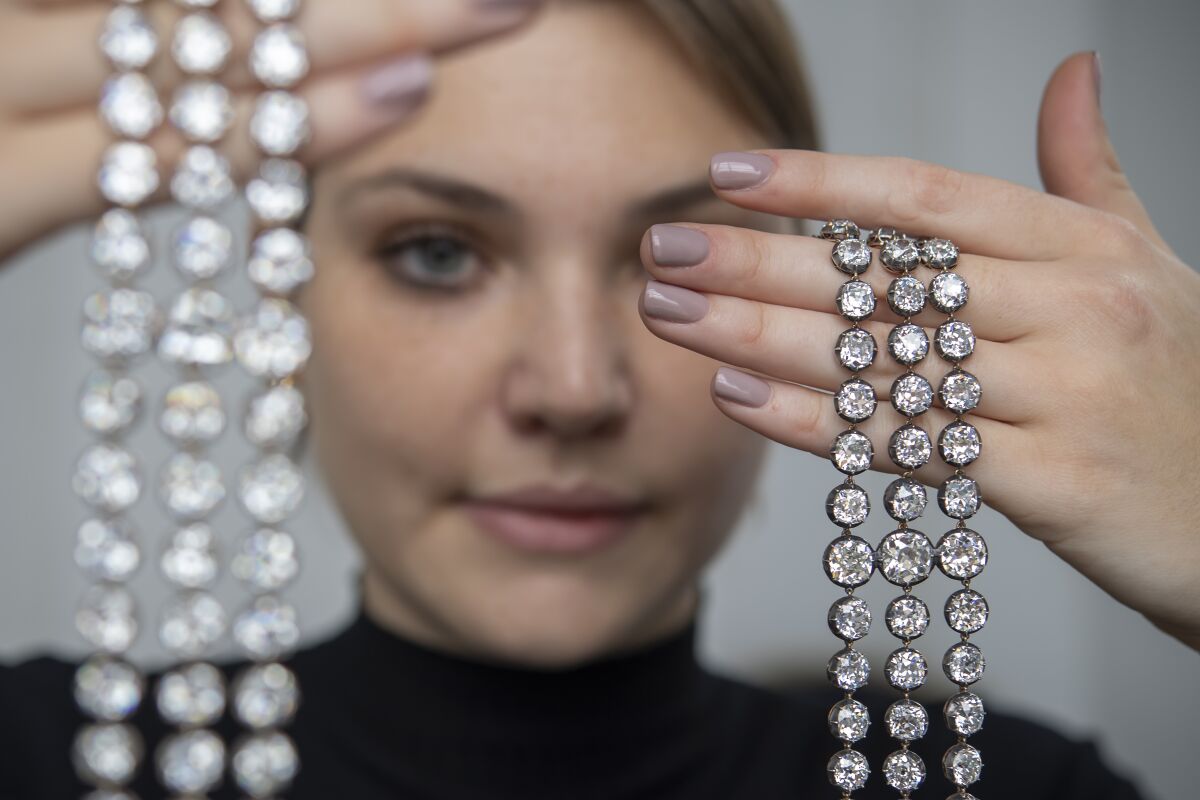 A Christie's employee displays a pair of diamond bracelets, with approximately 140 to 150 carats and owned by Queen Marie-Antoinette of France, in silver and yellow gold, circa 1776, during a preview at the Christie's, in Geneva, Switzerland, on Wednesday, Nov. 3, 2021. It is estimated to sell between 2,000,000 - 4,000,000 Swiss francs. The auction will take place in Geneva on Nov. 9. (Martial Trezzini/Keystone via AP)