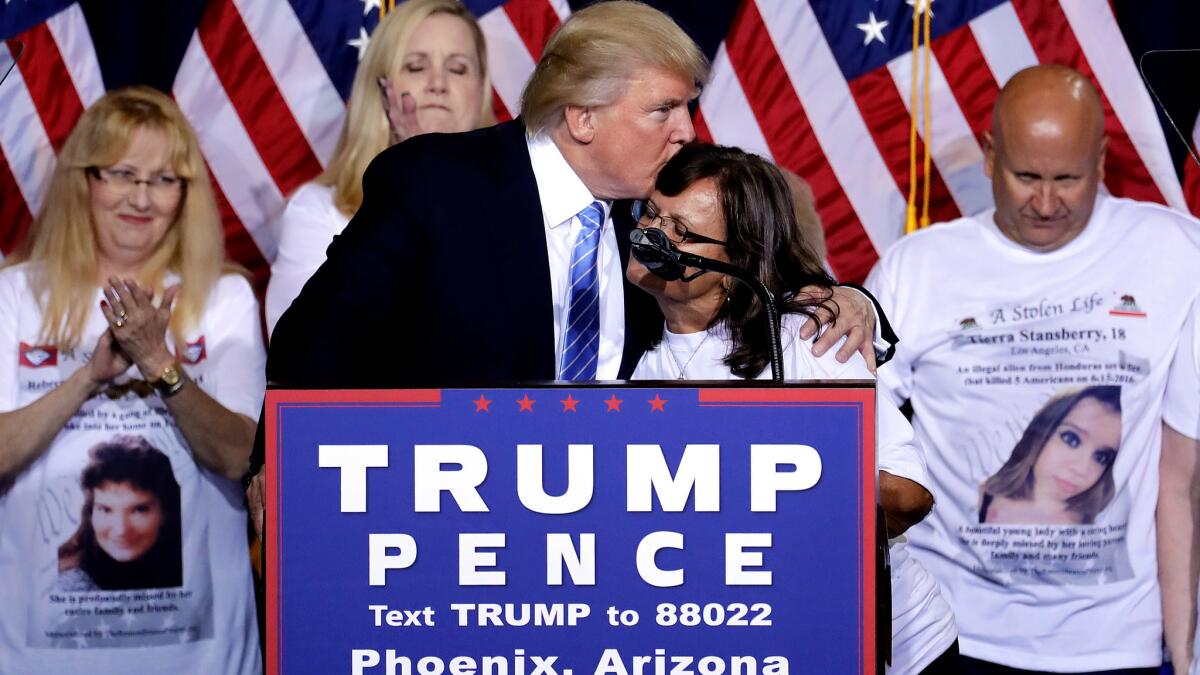 Republican presidential candidate Donald Trump embraces a mother whose child was killed by a person living in the country without legal permission after delivering an immigration policy speech at a campaign rally in Arizona on Wednesday.