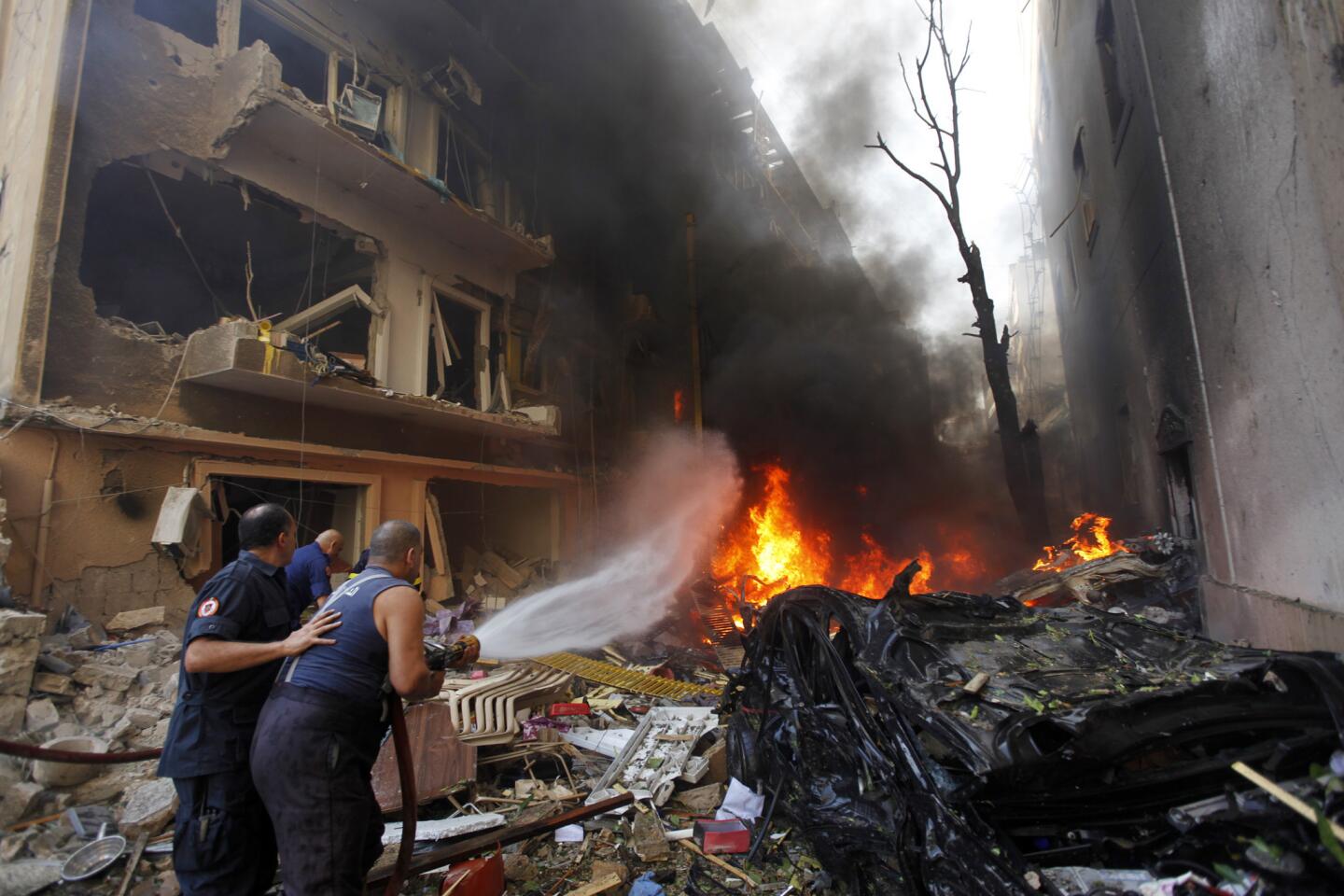 Lebanese firefighters extinguish burning cars at the scene of an explosion in the mostly Christian neighborhood of Achrafiyeh in Beirut.