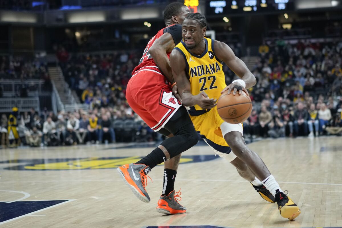 Indiana Pacers guard Caris LeVert, right, drives around Chicago Bulls forward Javonte Green during the first half of an NBA basketball game in Indianapolis, Friday, Feb. 4, 2022. (AP Photo/AJ Mast)