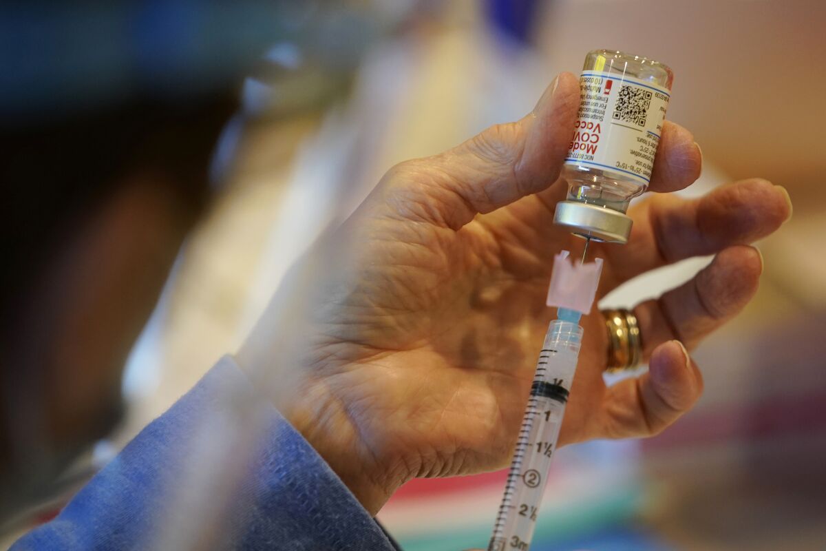A Pennsylvania Health Department worker fills a syringe with Moderna COVID-19 vaccine.