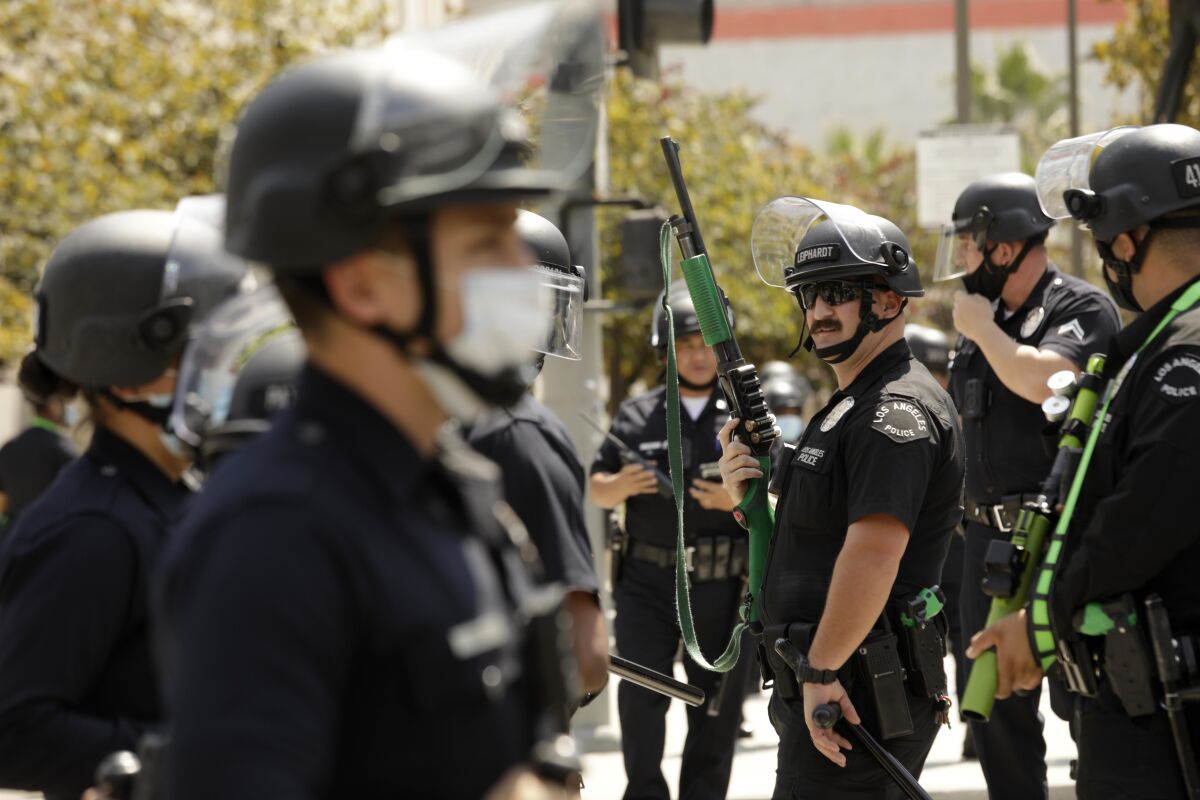 LAPD officers watch over a protest over vaccine mandates in downtown Los Angeles on Aug. 14. 