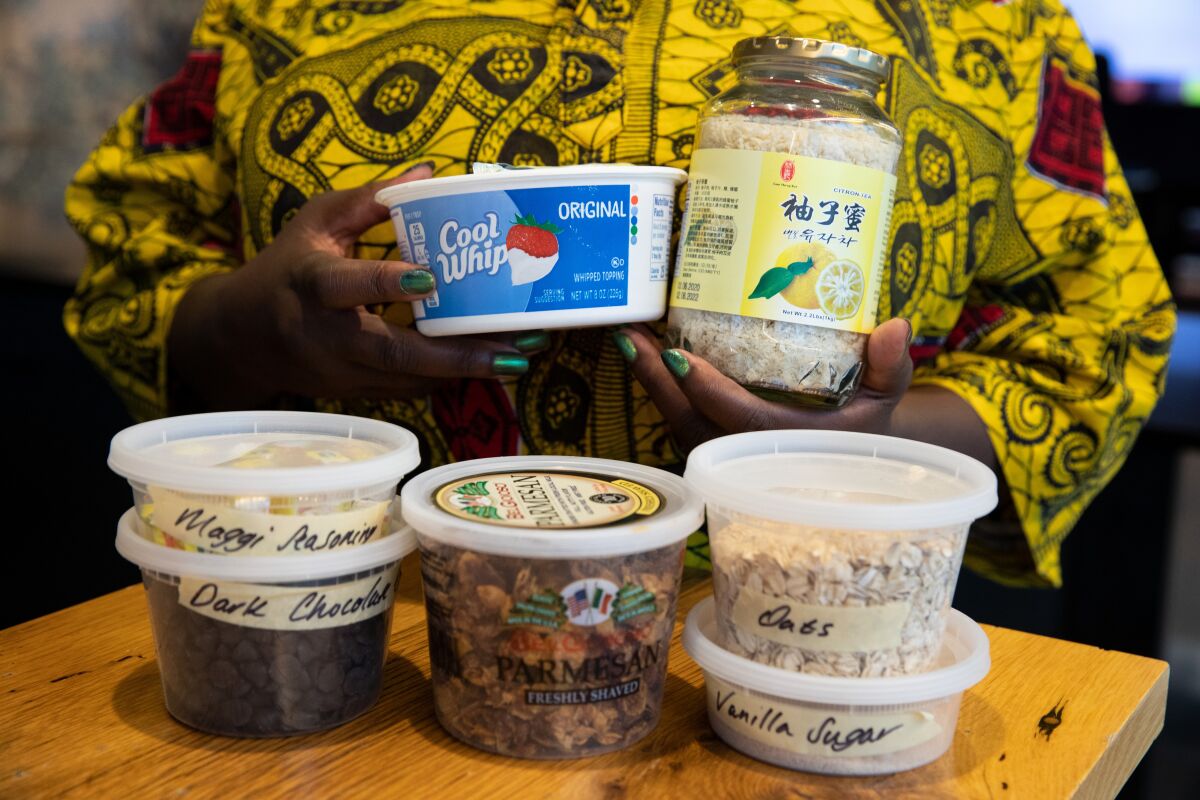 A woman holds a variety of containers she uses for storage. 