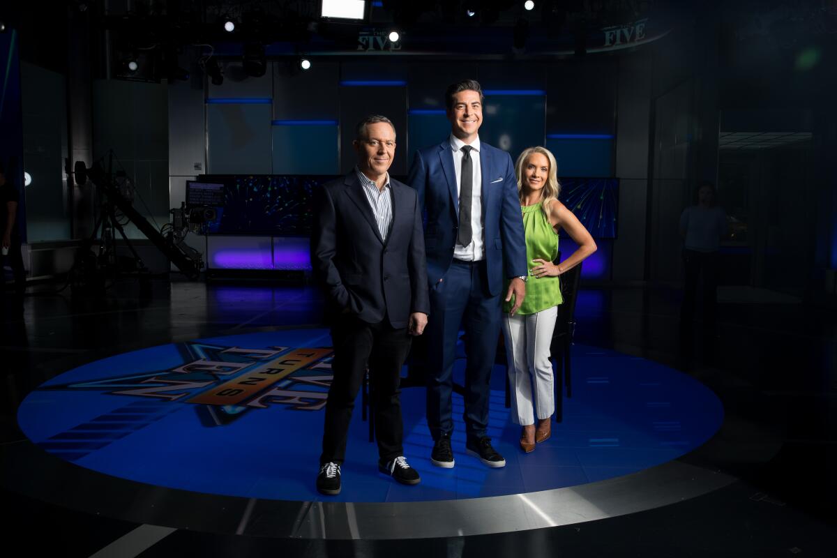 Two men and a woman stand on the set of Fox News series "The Five"
