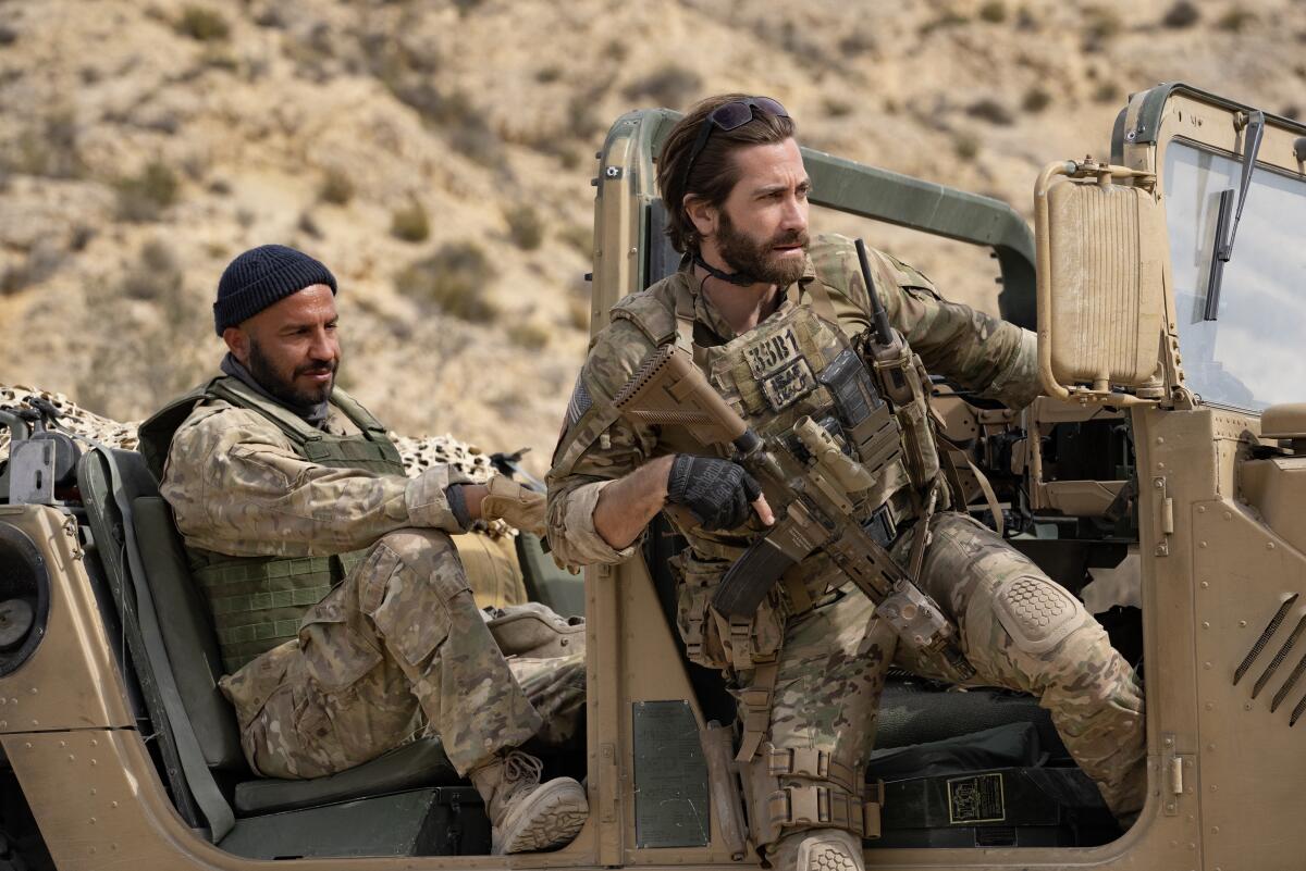Two men in desert camouflage in a jeep