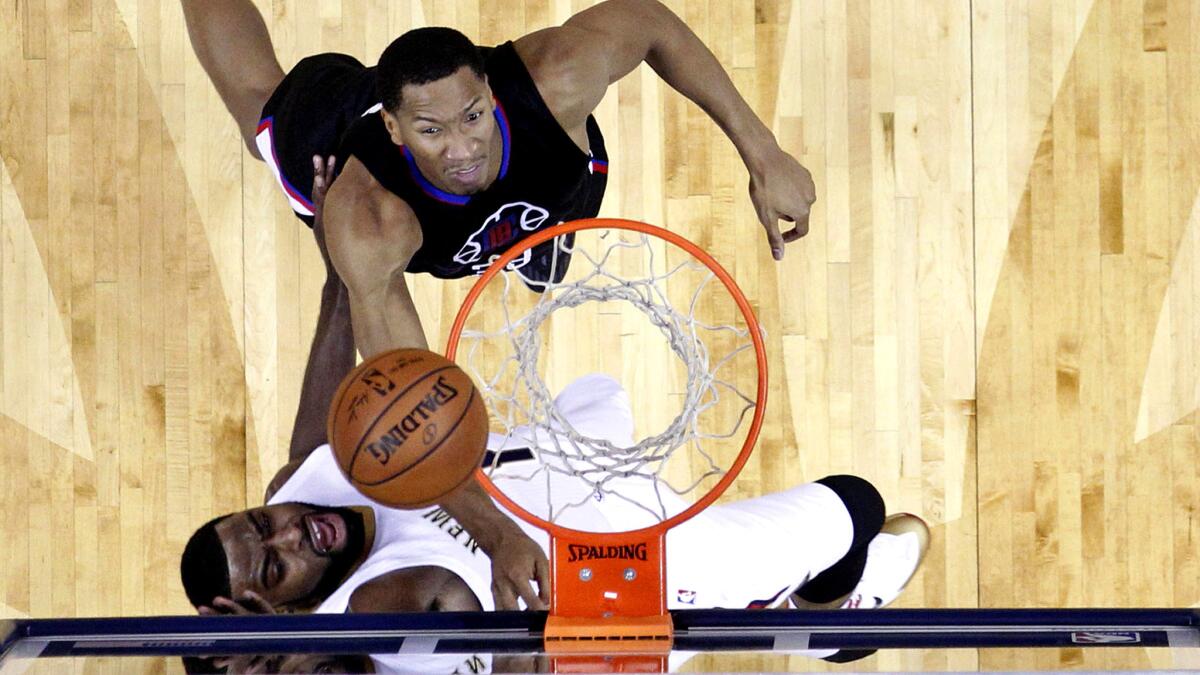 Clippers forward Wesley Johnson, top, and Pelicans guard Tyreke Evans battle for a rebound during the first half Thursday night.