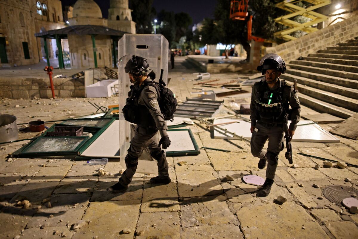 Israeli security forces walk amid debris 