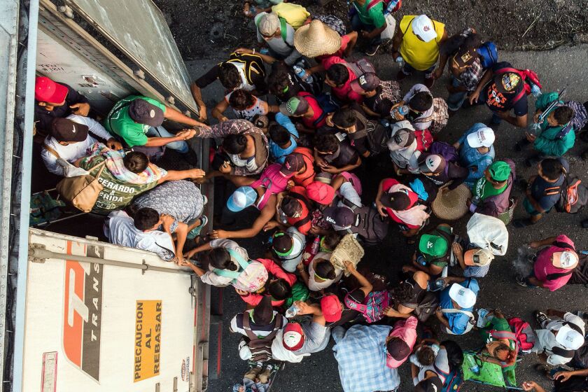 Honduran migrants taking part in a caravan heading to the U.S., get on a truck near Pijijiapan, Mexico.