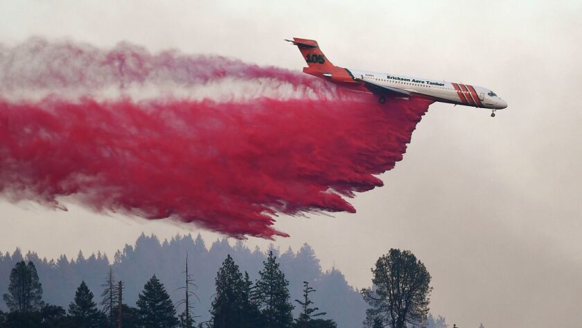 An air tanker drops fire retardant on the Carr fire as it spreads toward the town of Lewiston near Redding.