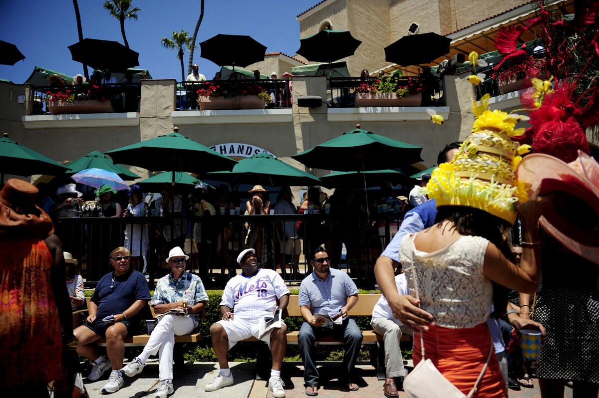 Race attendees observe women's colorful derby hats during the opening day of horse racing at the Del Mar racetrack on. By 3 p.m. Wednesday, over 20,000 Southern California horse racing fans were in attendance.