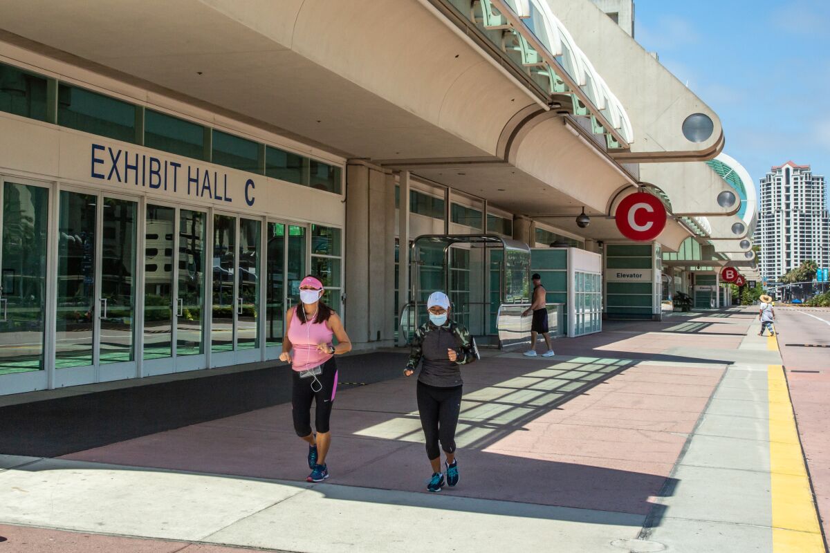 Joggers pass the San Diego Convention Center on Tuesday, during the week that would have marked the 51st Comic-Con