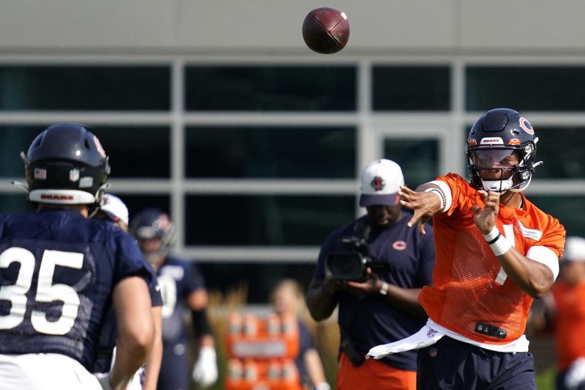 Chicago Bears quarterback Justin Fields, right, works with running back Ryan Nall (35) during NFL football practice in Lake Forest, Ill., Saturday, July 31, 2021. (AP Photo/Nam Y. Huh)