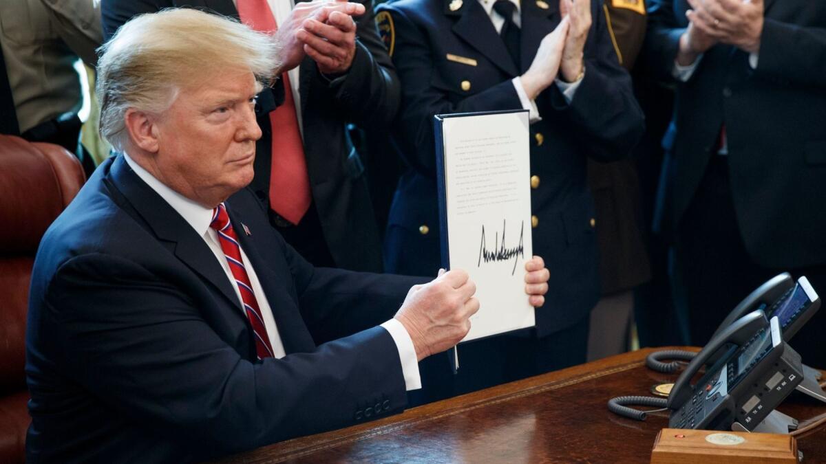 President Trump shows off his veto of Congress' challenge to his declaration of a national emergency at the U.S.-Mexico border.