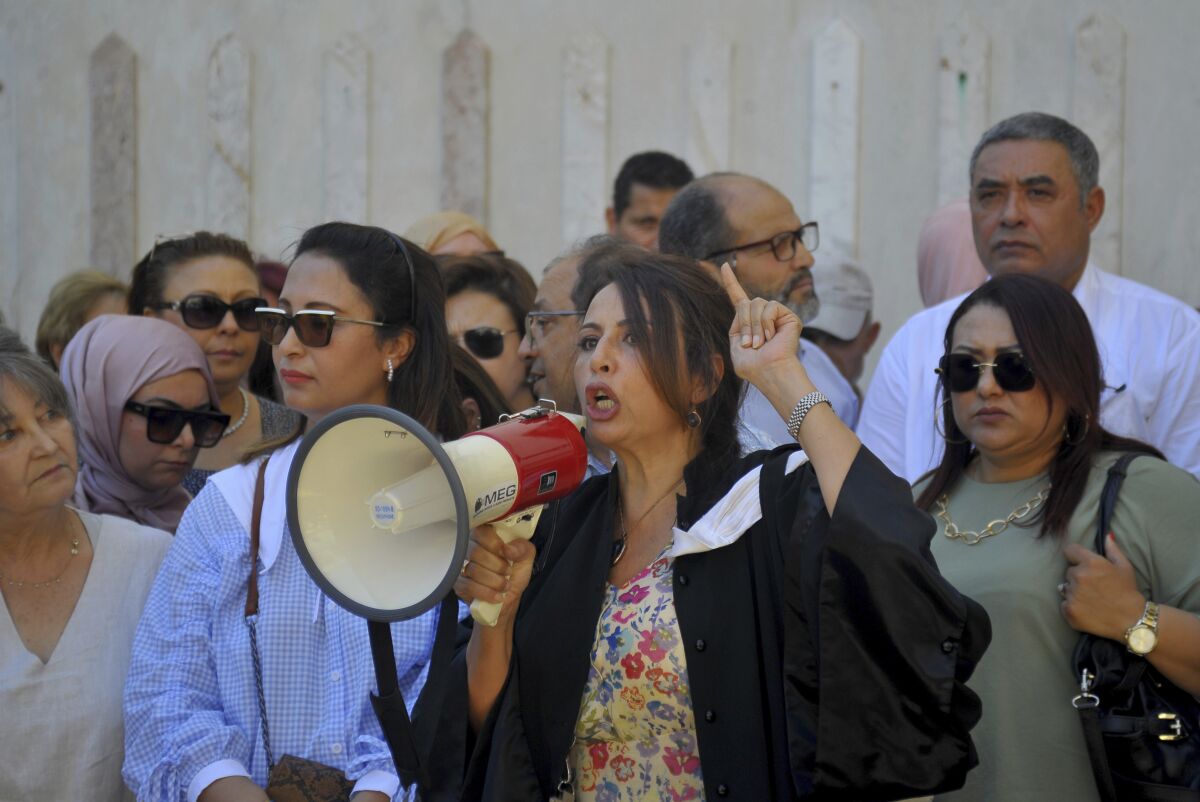 Lawyers and activists gather on the steps of the Palace of Justice during a protest in Tunis, Tunisia, Wednesday, June 8, 2022. Tunisian lawyers and judges held a small protest outside the capital’s courts Wednesday as part of their weeklong strike following the president’s dismissal of 57 judges. (AP Photo/Hassene Dridi)
