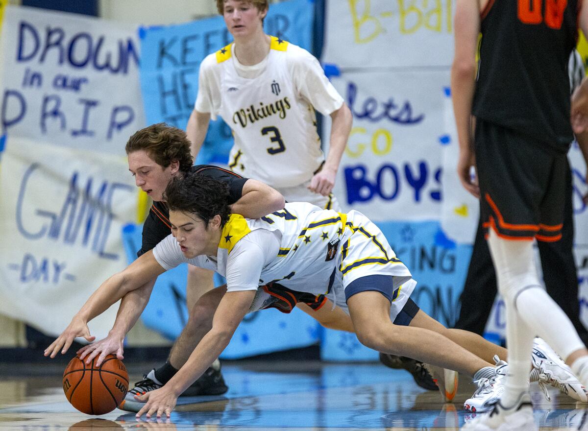 Huntington Beach's Cole Steiner and Marina's Bohdi Armstrong battle for a loose ball during Friday's game.