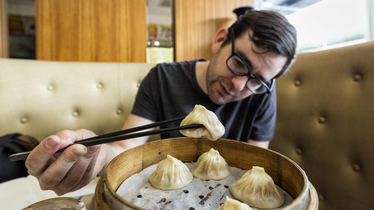 Chef-turned-food-writer Christopher St. Cavish, at Zun Ke Lai restaurant in Shanghai, demonstrates how a dumpling droops when picked up.